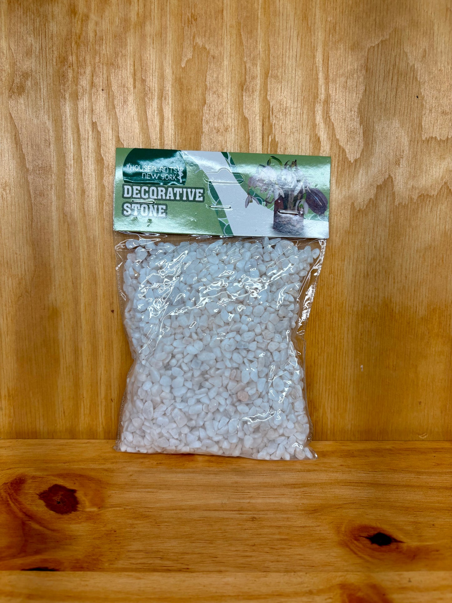 Bag of decorative stone with a label on a wooden surface