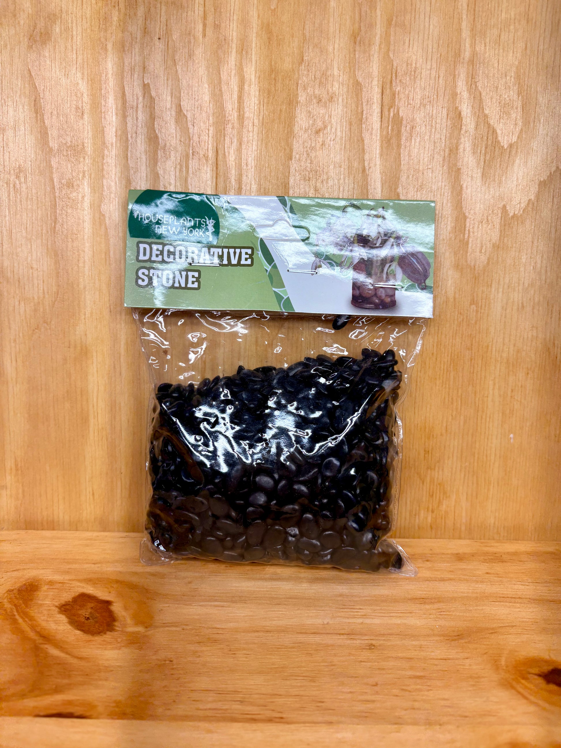 Bag of decorative stone with a label on a wooden surface