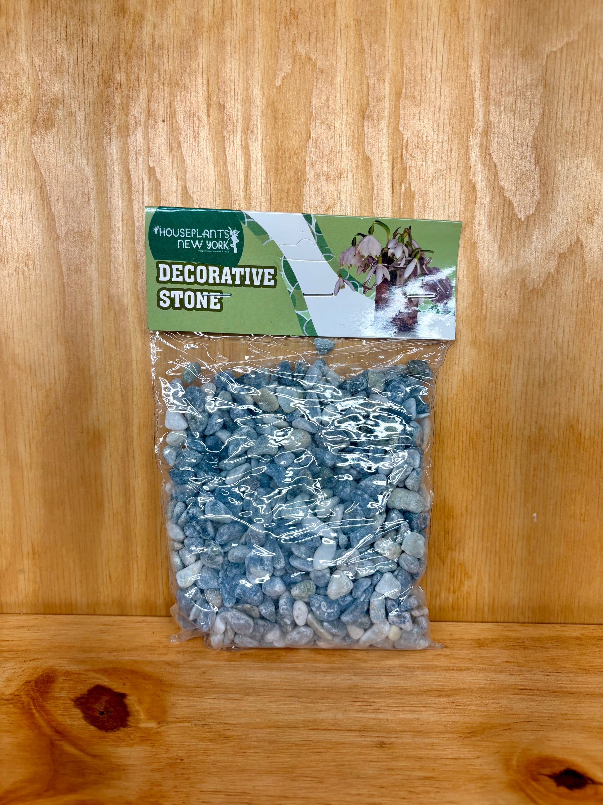 Bag of decorative stones with a label on a wooden surface